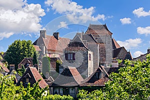 Neat medieval brick buildingsÂ with sloping tiled roofs of antique Loubressac village.Â Lot, Occitania, Southwestern France